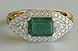 yellow 18kt gold, three-stone engagement ring, emerald cut emerald, trillion cut diamonds, diamond halo ring